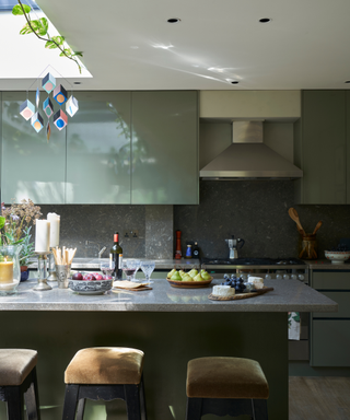A green kitchen with granite countertops.