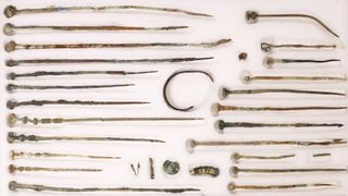 A collection of more than two-dozen bronze robe pins.