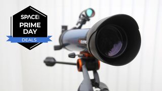 The Celestron Inspire 100AZ refractor telescope aimed to the right of the screen with aperture and finderscope visible, on a white background with a black Space.com Prime Day deals badge in the upper-left corner. 
