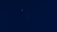 mars glows red next to a cluster of stars, the beehive cluster.