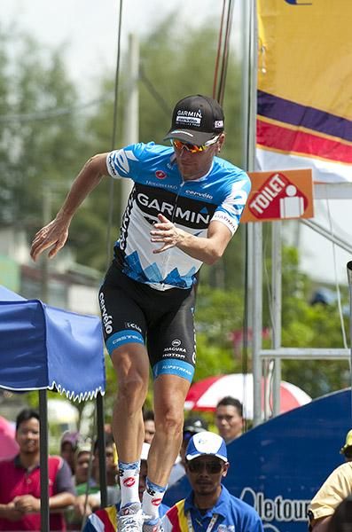 Tour leader David Zabriskie (Garmin Barracuda) does a little jig as he steps onto the podium in Parit Sulong.