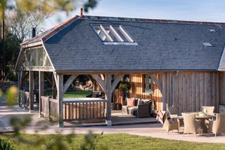 hipped roof extension to timber clad bungalow with veranda