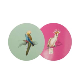 green and pink round placemats, with printed parrots