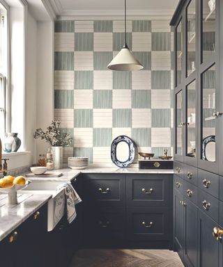 blue and white tiles on kitchen walls with dark blue cabinetry