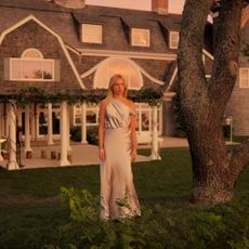 A woman (Milly Alcock as Simone) stands on a cliff in front of a mansion, in episode 105 of Sirens.
