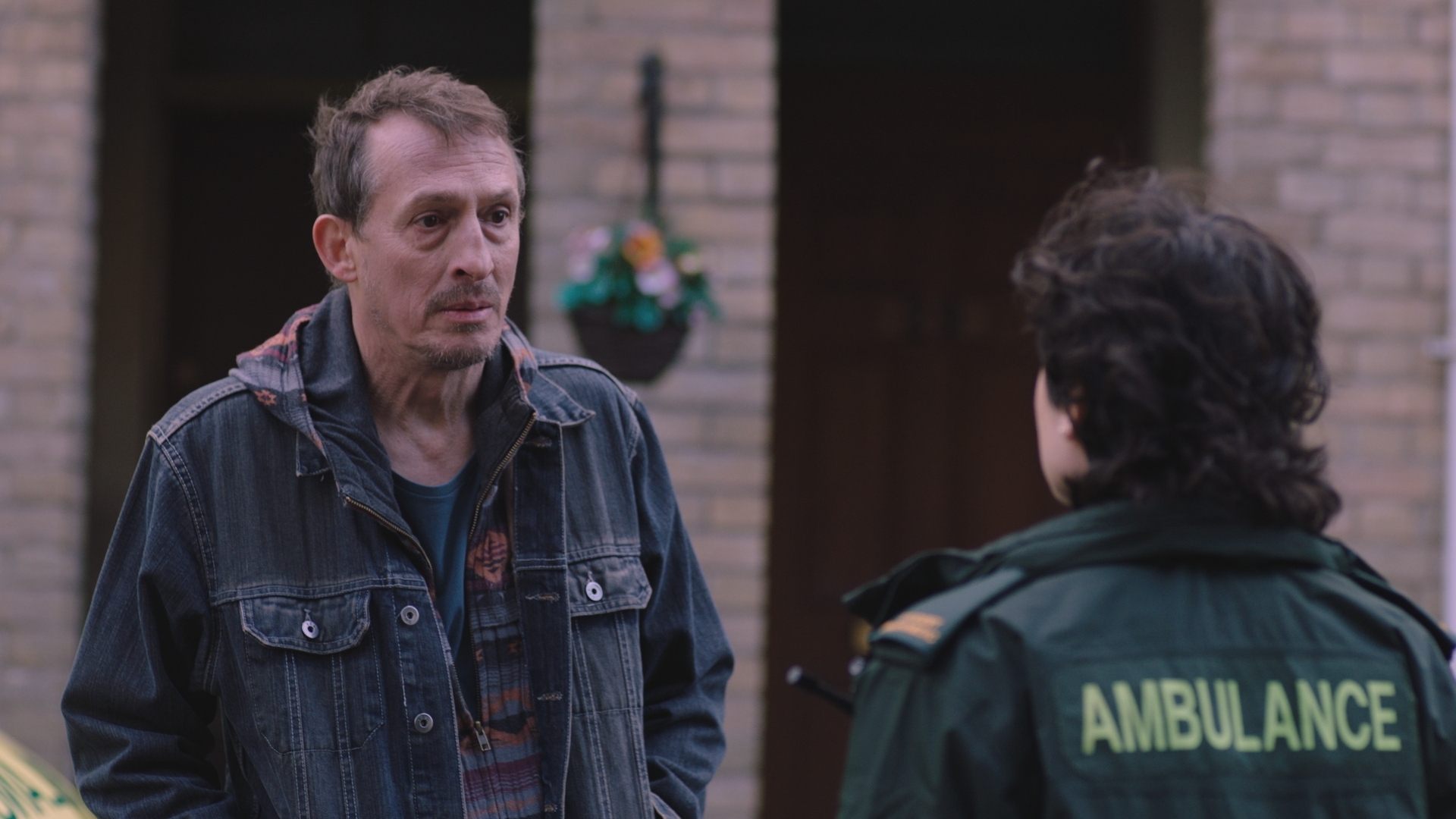 A dishevelled Samuel talks to Indie outside the ambulance station.