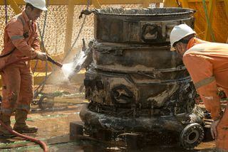 Bezos Expeditions crew members work with the thrust chamber of a recovered F-1 rocket engine from the Saturn V rocket that launched one of NASA's historic Apollo moon missions in this photo.