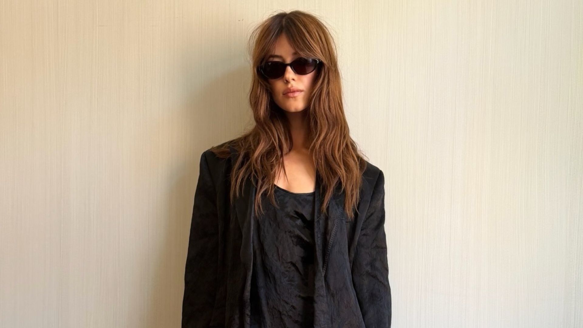Daisy Edgar Jones wears a black linen minidress with a matching blazer and beige square-toe heels.