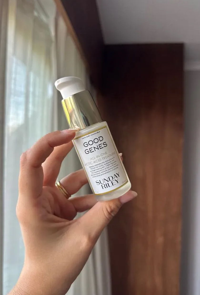 A photo of a hand holding a bottle of Sunday Riley Good Genes serum