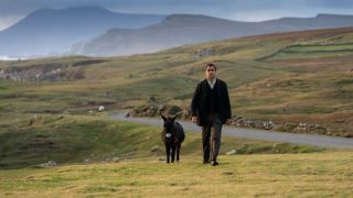 Colin Farrell and Jenny the donkey walking up a hill