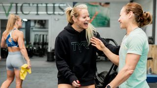 Dani Speegle laughing with another woman in a gym
