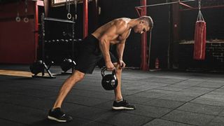 Man performs one-handed row with kettlebell