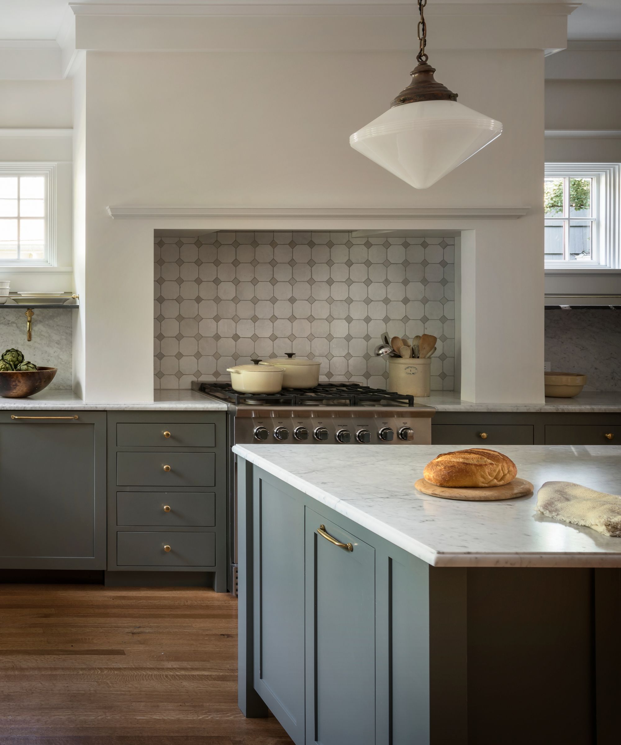 A craftsman kitchen with blue cabinets, white walls, and a tiled backsplash