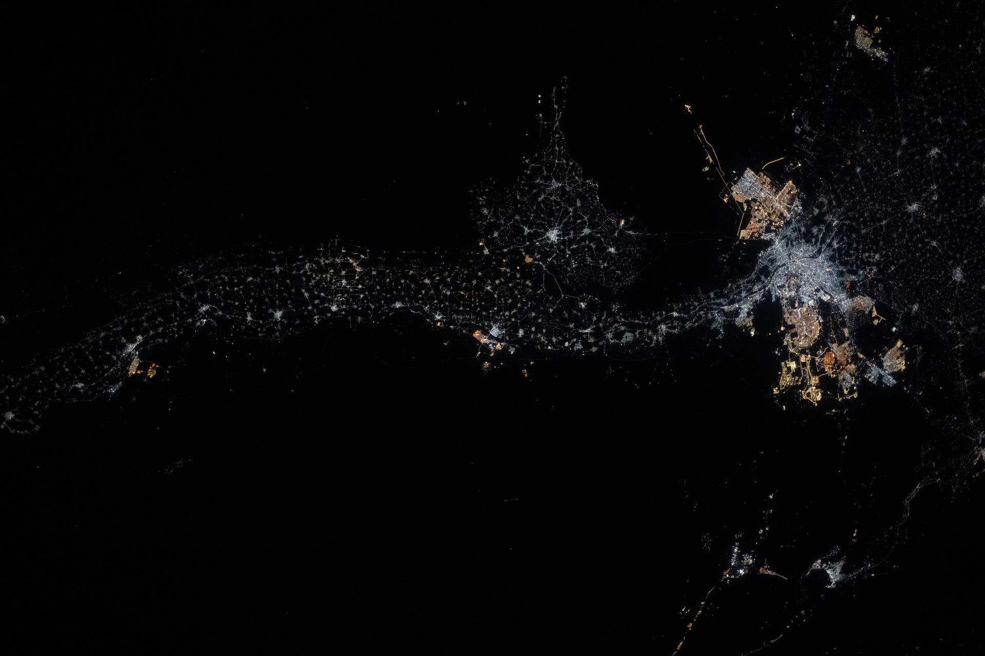 A string of dots showing the outline of the Nile River is seen across the dark surface of Earth
