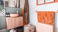 Boho bathroom with pink sink and orange towel