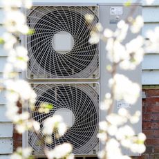 Exterior of house, with outdoor unit air source heat pump