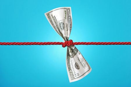 twenty dollar bill tied in a red cord against a blue background