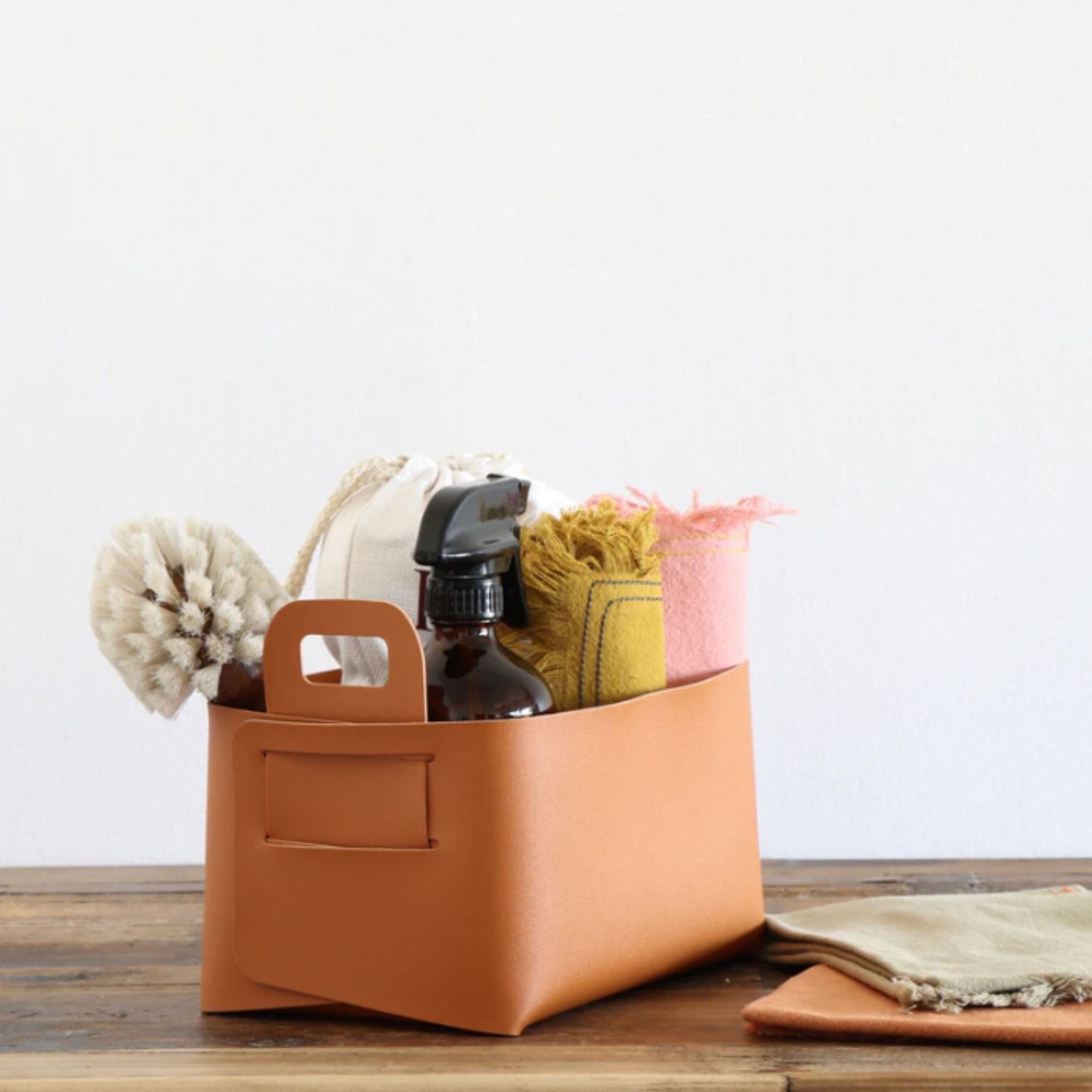 Keranjang penyimpanan oranye dengan bahan pembersih di dalamnya