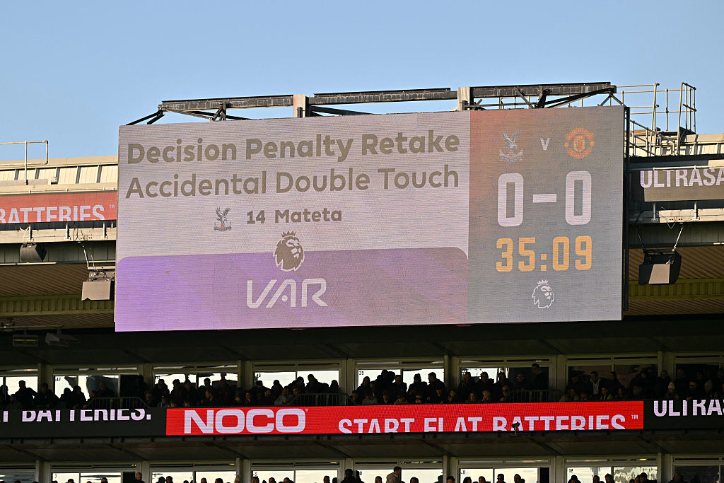 A screen shows penalty retake decision into the VAR check of Crystal Palace&#039;s French striker #14 Jean-Philippe Mateta&#039;s first penalty, before he took and scored the retake, during the English Premier League football match between Crystal Palace and Manchester United at Selhurst Park in south London on November 30, 2025. (Photo by Glyn KIRK / AFP) / RESTRICTED TO EDITORIAL USE. No use with unauthorized audio, video, data, fixture lists, club/league logos or &#039;live&#039; services. Online in-match use limited to 120 images. An additional 40 images may be used in extra time. No video emulation. Social media in-match use limited to 120 images. An additional 40 images may be used in extra time. No use in betting publications, games or single club/league/player publications. /