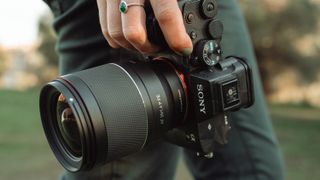 Samyang AF 35mm F1.4 P Sony FE attached to a Sony camera and held in a hand