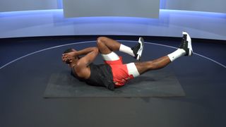 Peloton instructor Jermaine Johnson demonstrates the bicycle crunch exercise