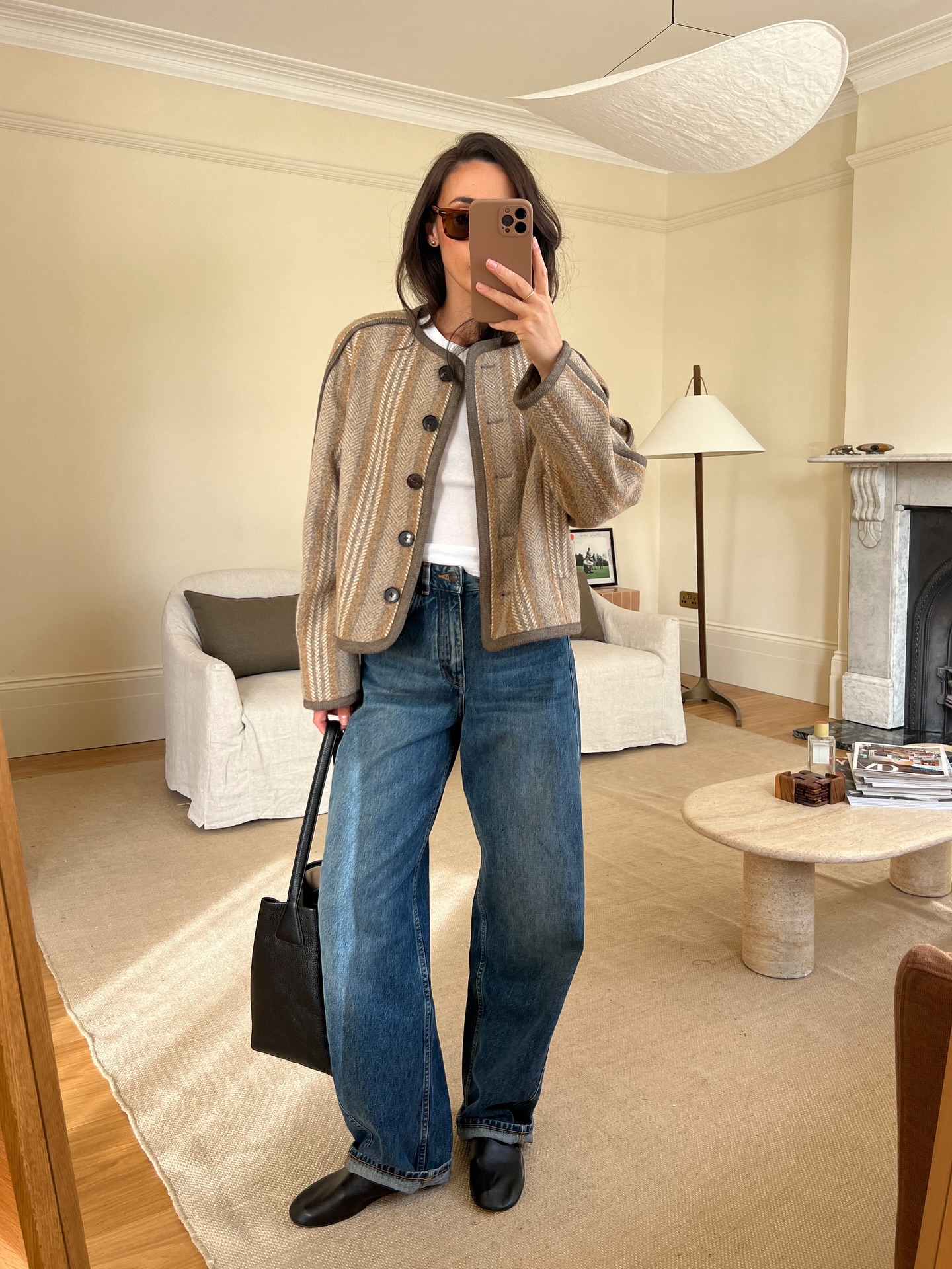 Influencer Emily Wells wearing a quilted jacket, barrel-leg jeans and loafers.