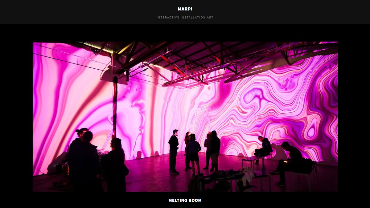 A screen capture of interactive artist Marpi&#039;s website, featuring his installation melting room in which pink colours swirl across the walls of a gallery space.