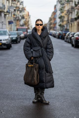 woman wearing belted puffer coat, pants, and boots