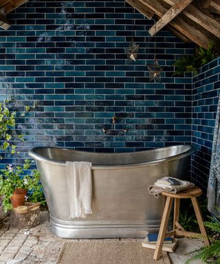 outdoor bathtub in steel outside with blue tiles