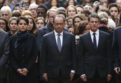 French President Hollande is flanked by cabinet leaders during a moment of silence Monday.