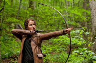 Katniss Everdeen (Jennifer Lawrence) holds a bow and arrow in the movie The Hunger Games.