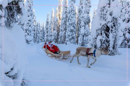 Santa sat in a sleigh being pulled by a reindeer