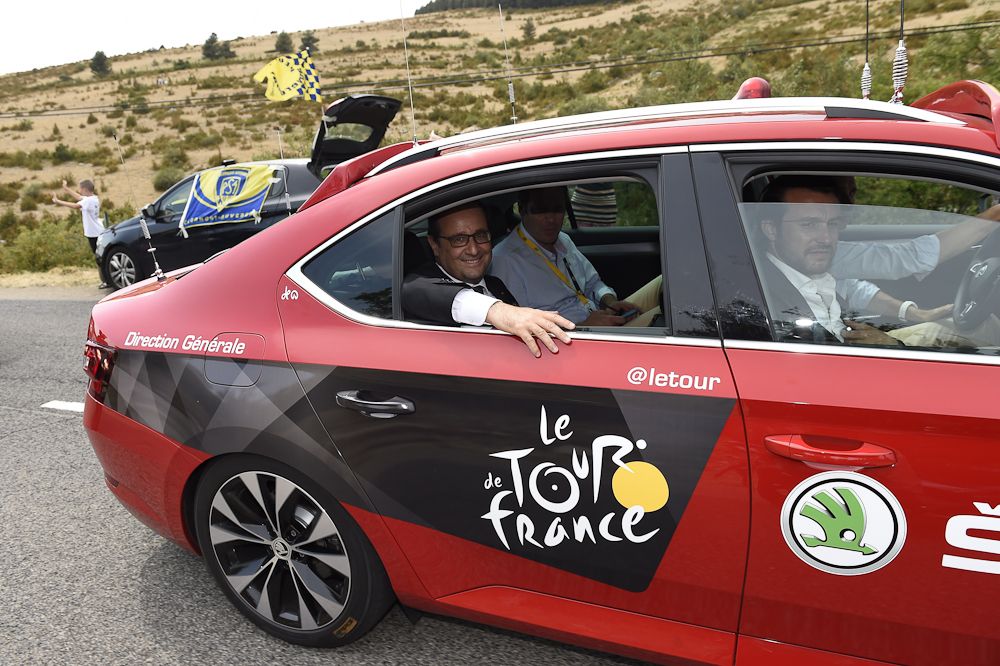 French President Francois Hollande smiles from an official car as he attends stage 14 of the Tour de France.