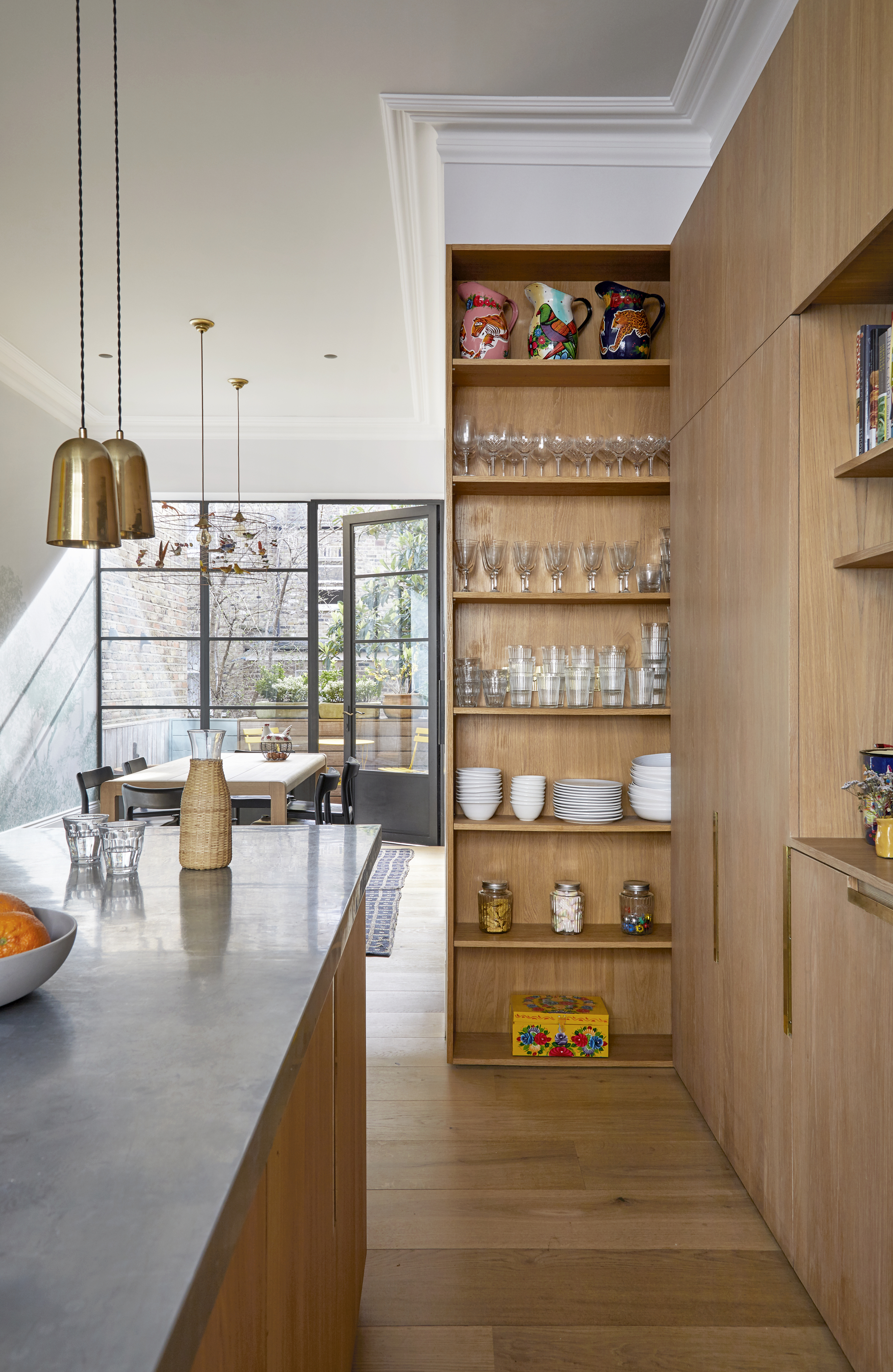 A kitchen with a pull out pantry with storage on the door