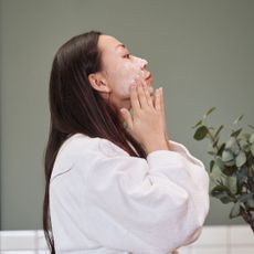 Best SPF for sensitive skin - woman applying cream in front of mirror