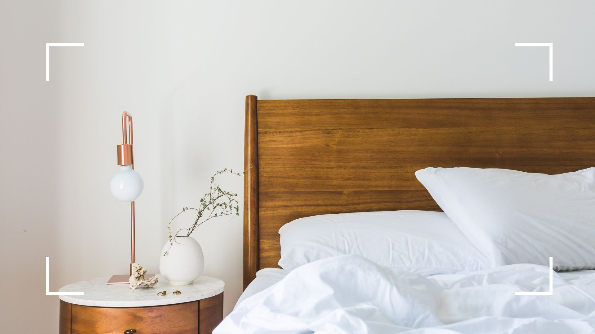 picture of neutral bedding on wooden bed with table 