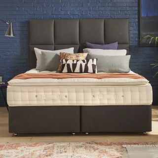 Hypos mattress on an upholstered bed in a dark bedroom