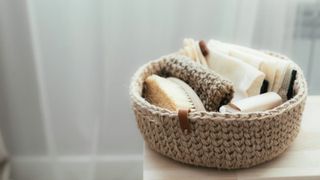 A woven basket on a counter filled with natural cleaning supplies