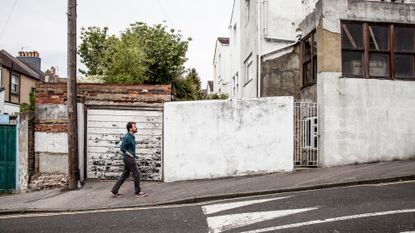 Man walking uphill in a town