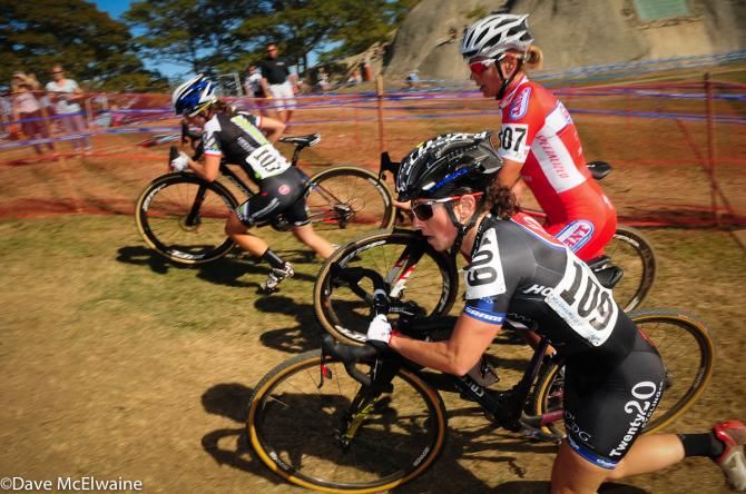 Arley Kemmerer ((C3-Twenty20 Cycling Co), Meredith Miller, and Kaitie Antonneau pushing their bikes past a set of stairs on lap two