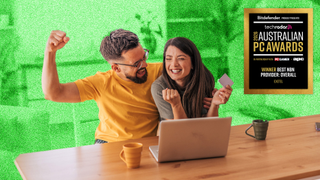Young couple looking excited sitting at a table in front of a laptop, with the Australian PC Awards 2026 badge for Best NBN Provider overlaid in the top right corner.