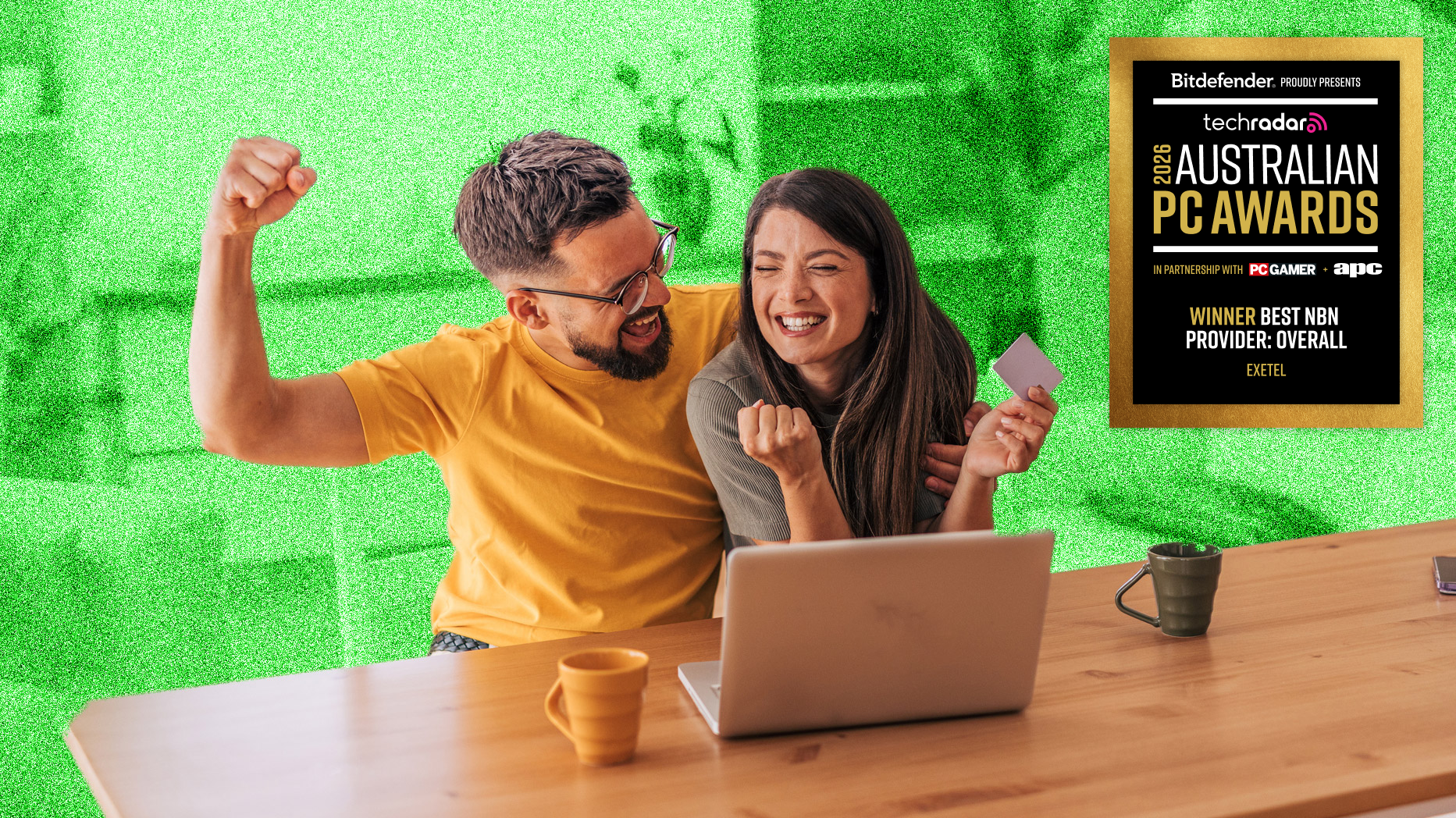 Young couple looking excited sitting at a table in front of a laptop, with the Australian PC Awards 2026 badge for Best NBN Provider overlaid in the top right corner.