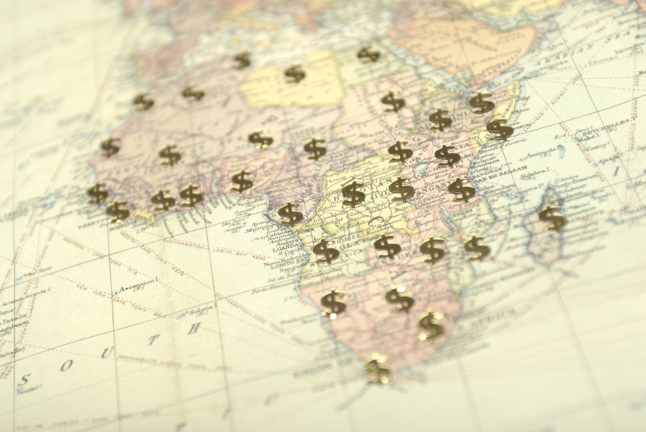 Dollar signs dot the countries of Africa on an old, yellow-tinged map