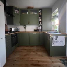 green kitchen with wood floor and wood worktops