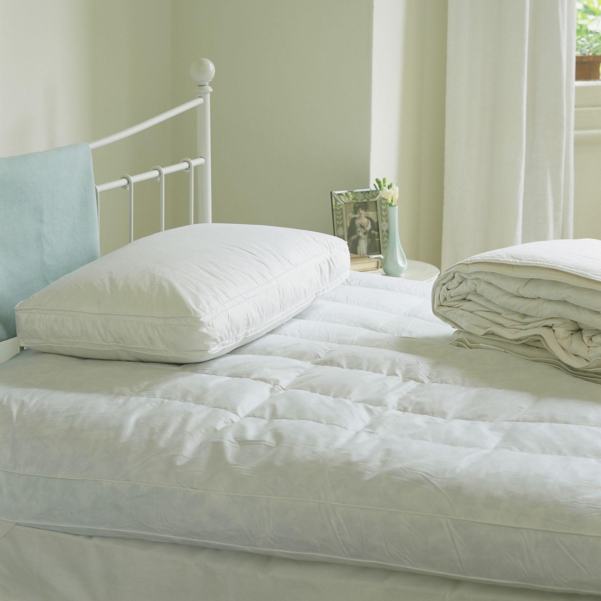 Bed without bedding with a pillow on top