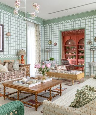 Living room with trellis paneling in green, upholstered sofa and armchair, wooden bobbin coffee table