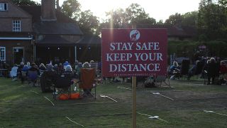 a sign about social distancing at a concert