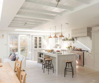 A luxury kitchen in white and wooden tones with an island in the middle