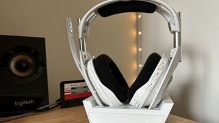 Astro A50 X headset in base station on a wooden desk
