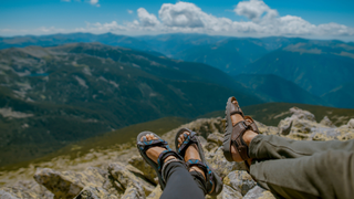 A pair of feet both in hiking sandals